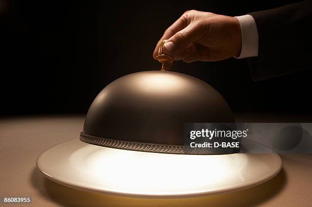 waiter opening the silver dome. - domed tray photos et images de collection
