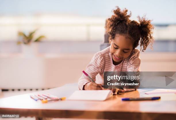 schattig zwarte meisje thuis ontspannen en tekenen op een papier. - child drawing stockfoto's en -beelden