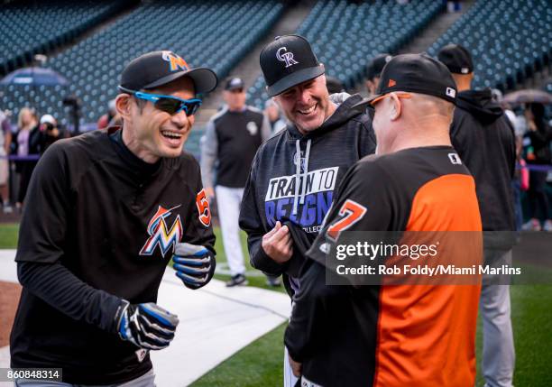 First base coach Perry Hill and Ichiro Suzuki of the Miami Marlins laugh with Mike Redmond of the Colorado Rockies before the game at Coors Field on...