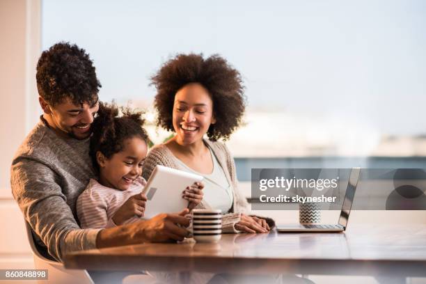 happy african american family using wireless technology at home. - mother happy reading tablet stock pictures, royalty-free photos & images