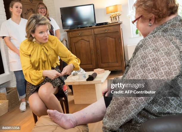 Queen Mathilde of Belgium talks with Marie-Agnes Zicot , a home ursing patient following a visit to the head office of the federation for 'Aide et...