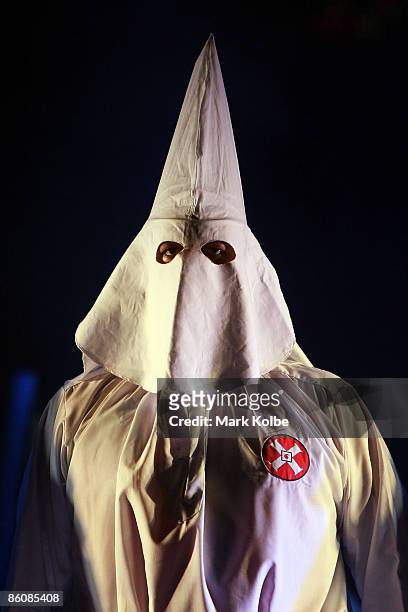Performer in the Klu Klux Klan dance number stands on stage during the "Jerry Springer: The Opera" photocall at the Sydney Opera House in Sydney,...