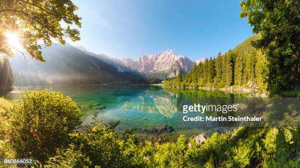 türkisfarbener alpensee mit bergpanorama idylle - idyllic lake stock-fotos und bilder