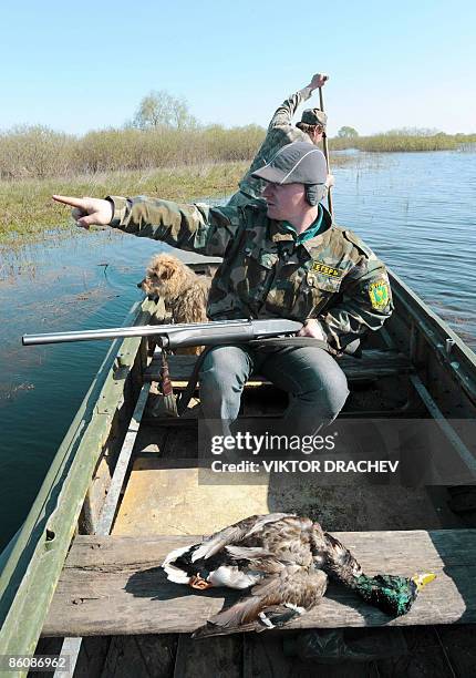 Belarussian game warden sits in a boat during a duck hunt in the backwaters of the Pripyat river some 270km south of Minsk near the village of Kremno...