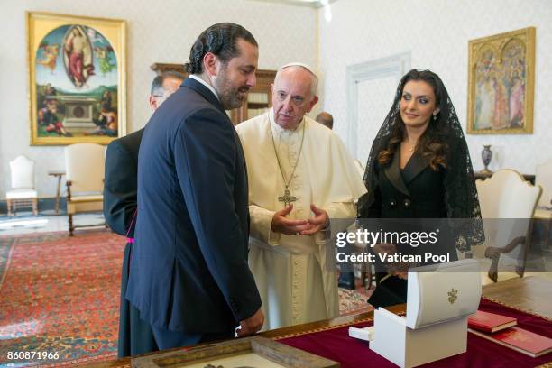 Pope Francis exchanges gifts with Lebanon Prime Minister Saad Hariri and his wife Lara Bashir El Alzem during a private audience at the Apostolic...