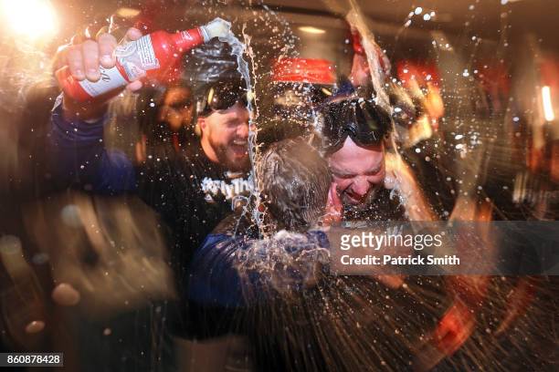 The Chicago Cubs celebrate in the locker room after defeating the Washington Nationals, 9-8, in game five of the National League Division Series at...