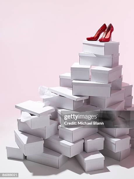 single pair of red shoes on top of shoe boxes - shopping coloured background stock pictures, royalty-free photos & images