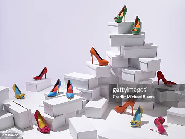 various shoes piled on shoe boxes - schuhwerk stock-fotos und bilder