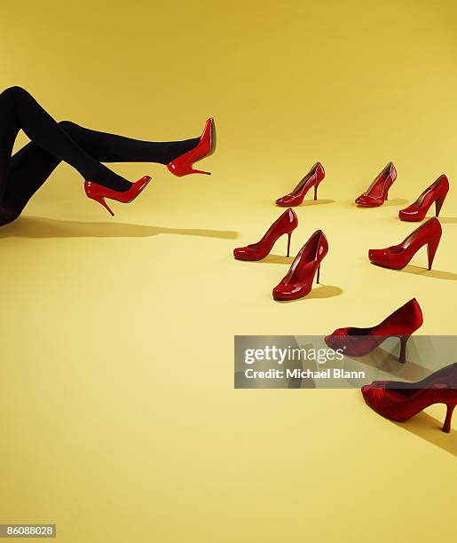 woman trying on red shoes - red shoe stockfoto's en -beelden