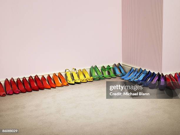shoes lined up by color along the wall - abundance stock pictures, royalty-free photos & images