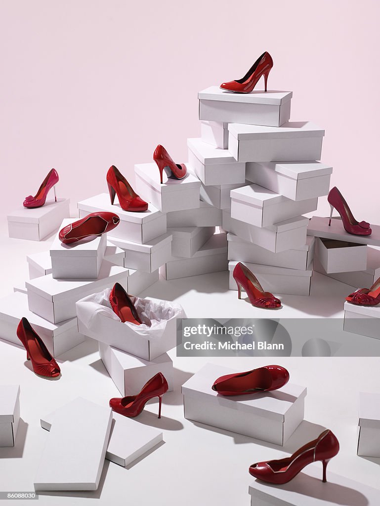 Various red shoes on top of shoe boxes