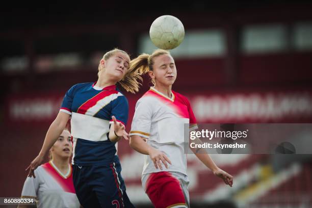 twee vrouwelijke voetbal rivalen post de bal op een wedstrijd. - header stockfoto's en -beelden