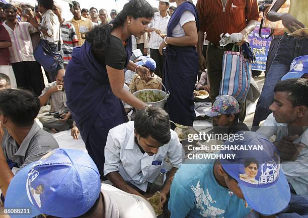 Volunteer from Bahujan Samaj Party gives food to supporters of party president and Uttar Pradesh state Chief Minister Mayawati Kumari during a...