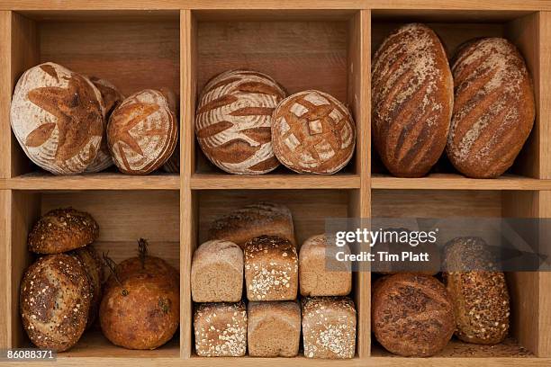 various artisan loaves of bread. - bakery shelves stock pictures, royalty-free photos & images