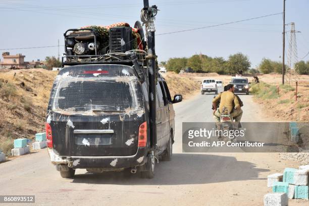 Iraqi federal police drive down a street near a former Kurdish military position on October 13, 2017 in the northern Iraqi town of Taza Khurmatu,...