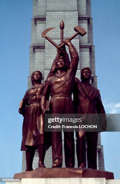 Sculpture en bronze devant la tour du Juche représentant un ouvrier, un paysan et un intellectuel en juillet 1987 à Pyongyang, Corée du Nord.