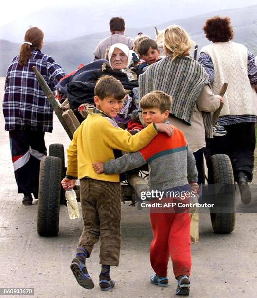 Two ethnic Albanian refugee children turn back to look at the photographer as they cross with their family into Albania on the border checkpoint of...