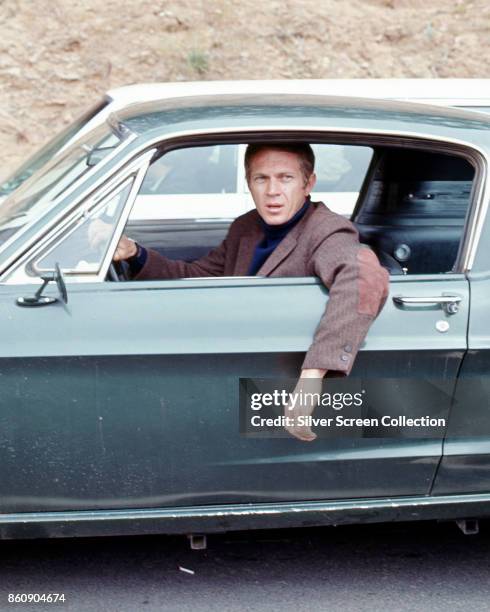 American actor Steve McQueen hangs his arm out the driverside window of a car in a scene from 'Bullitt' , California, 1968.