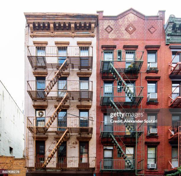fire escape ladders on buildings in soho neighborhood, new york city, usa - soho new york stockfoto's en -beelden