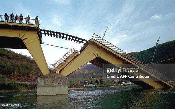 People look down from the destroyed railway bridge on the river Lim near Bistrica, some 280 km southwest of Belgrade, Thursday 15 April 1999, This...