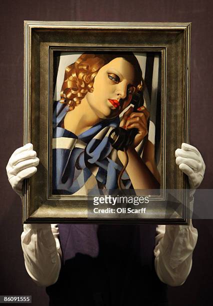 Gallery technician at Sotheby's auction house holds a painting by Tamara de Lempicka entitled 'Le Telephone II' from 1930, which is expected to fetch...