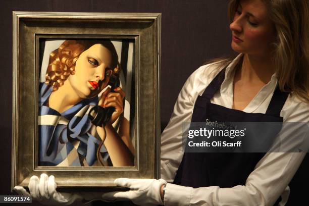 Gallery technician at Sotheby's auction house admires a painting by Tamara de Lempicka entitled 'Le Telephone II' from 1930, which is expected to...