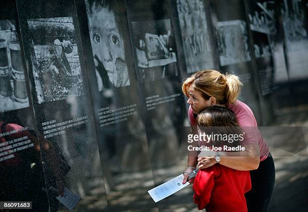 Genevieve Pared hugs her son Jason Pared as they look at photographs on display as they visit the Holocaust Memorial during Yom HaShoah-Holocaust...