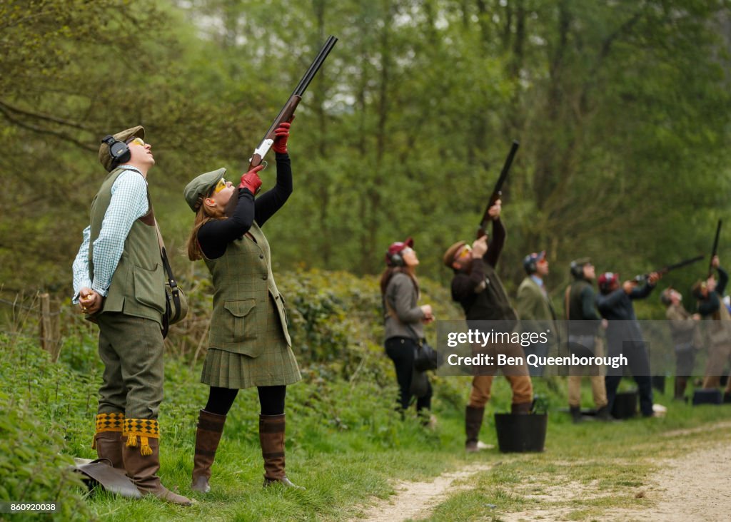 A woman aiming a rifle during at clay pigeon shoot