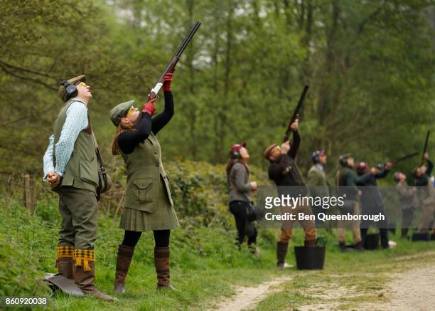 a woman aiming a rifle during at clay pigeon shoot - clay shooting fotografías e imágenes de stock