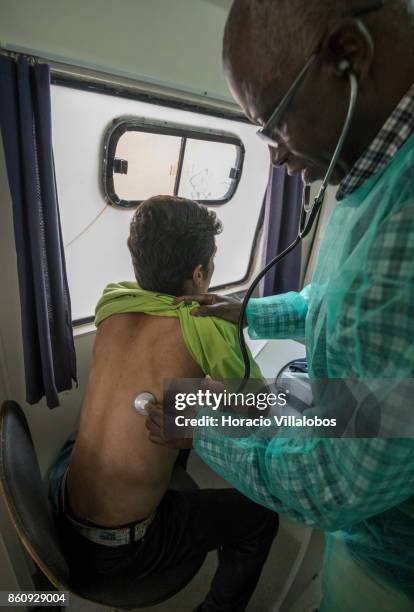 Dr. Carlos Gomes checks the lung function of a new participant in a van near Praca Espanha where patients are given their daily dose of 85 milligrams...