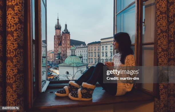 woman enjoyng krakow city from the window - hostel stock pictures, royalty-free photos & images
