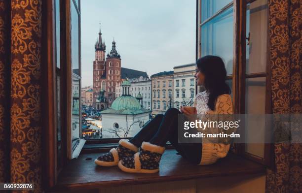 woman enjoyng krakow city from the window - pousada de juventude imagens e fotografias de stock