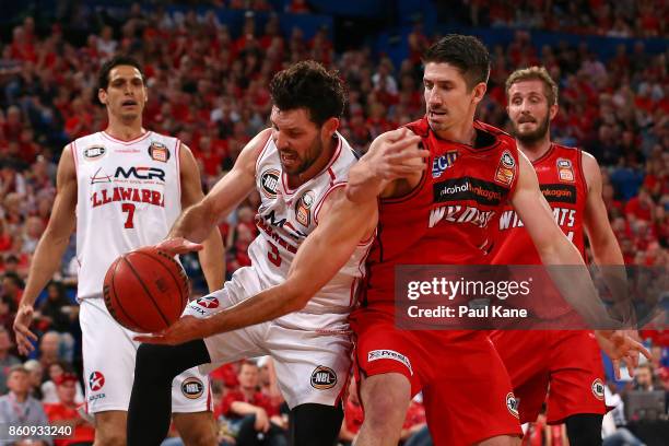 Kevin White of the Hawks gathers the ball against Greg Hire of the Wildcats during the round two NBL match between the Perth Wildcats and the...