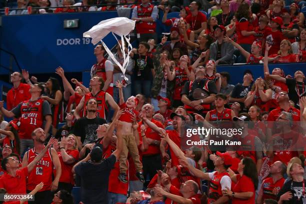 Spectators attempt to catch parachutes with prizes during the round two NBL match between the Perth Wildcats and the Illawarra Hawks at Perth Arena...