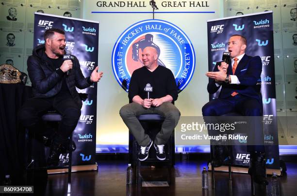 Michael Bisping and Georges St-Pierre speak to eachother during the UFC 217 press conference with Dana White at the Hockey Hall of Fame on October...