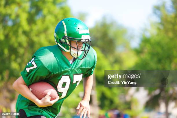 high school  or university american football player playing in field - college football player stock pictures, royalty-free photos & images
