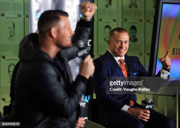 Georges St-Pierre reacts as Michael Bisping speaks to the media during the UFC 217 press conference at the Hockey Hall of Fame on October 13, 2017 in...