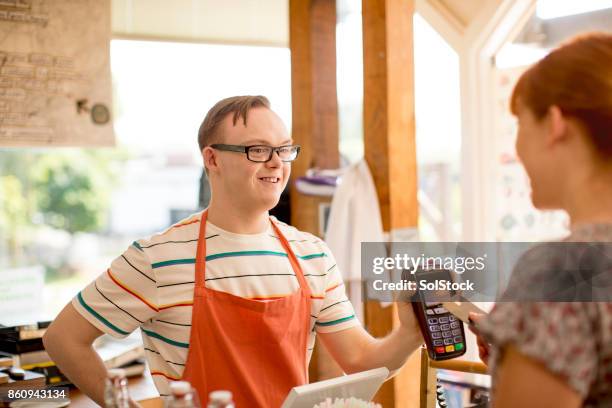 uitvoeren van een betaling in de boerderij-cafe - intellectually disabled stockfoto's en -beelden