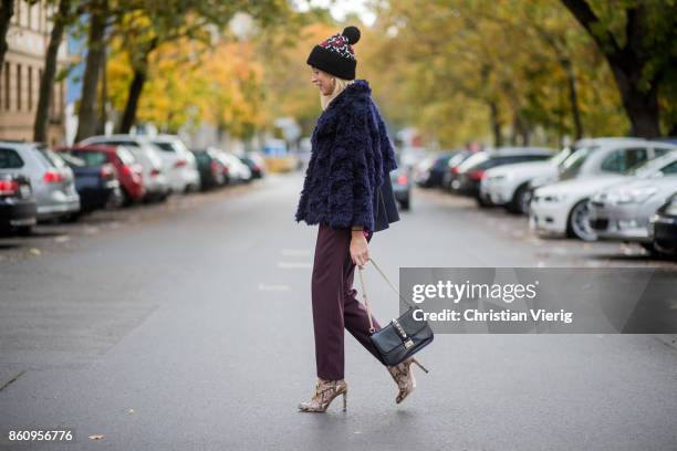 Sonia Lyson wearing Jimmy Choo boots with snake skin print, navy fake fur cropped jacket Nobi Talai, bordeaux pleated trousers Nobi Talai, wool...
