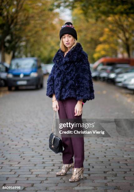 Sonia Lyson wearing Jimmy Choo boots with snake skin print, navy fake fur cropped jacket Nobi Talai, bordeaux pleated trousers Nobi Talai, wool...