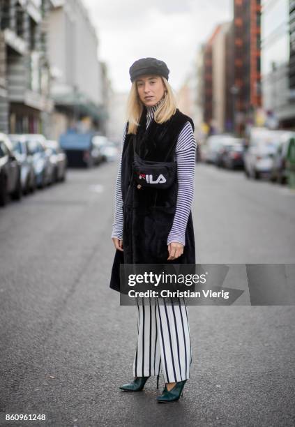 Sonia Lyson wearing shoes Jimmy Choo, black white striped pants Topshop, cropped turtleneck Longchamp, black long fake fur vest Lala Berlin, cap...