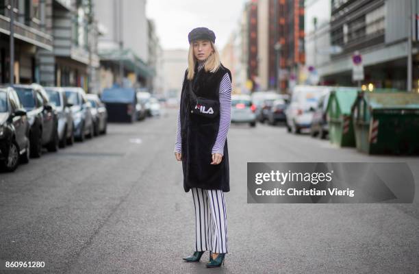 Sonia Lyson wearing shoes Jimmy Choo, black white striped pants Topshop, cropped turtleneck Longchamp, black long fake fur vest Lala Berlin, cap...