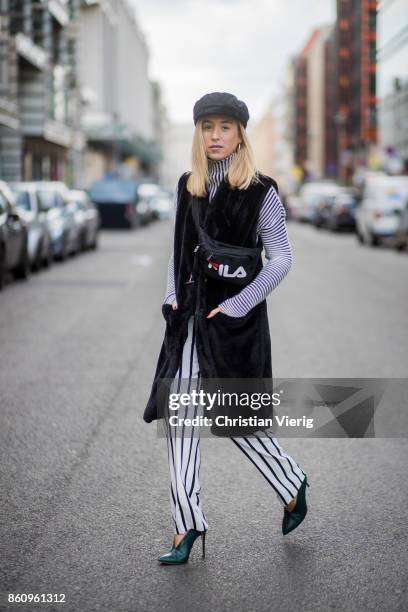 Sonia Lyson wearing shoes Jimmy Choo, black white striped pants Topshop, cropped turtleneck Longchamp, black long fake fur vest Lala Berlin, cap...