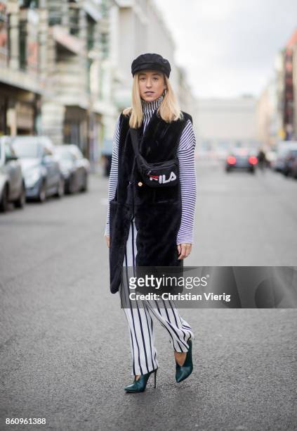 Sonia Lyson wearing shoes Jimmy Choo, black white striped pants Topshop, cropped turtleneck Longchamp, black long fake fur vest Lala Berlin, cap...
