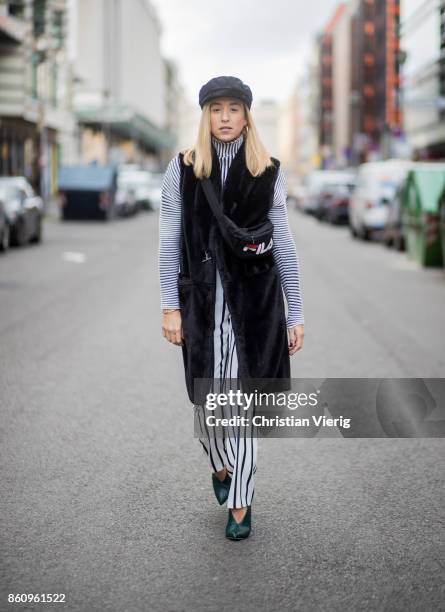 Sonia Lyson wearing shoes Jimmy Choo, black white striped pants Topshop, cropped turtleneck Longchamp, black long fake fur vest Lala Berlin, cap...