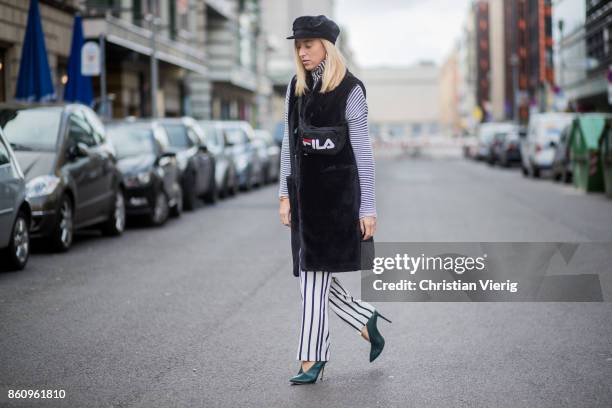 Sonia Lyson wearing shoes Jimmy Choo, black white striped pants Topshop, cropped turtleneck Longchamp, black long fake fur vest Lala Berlin, cap...