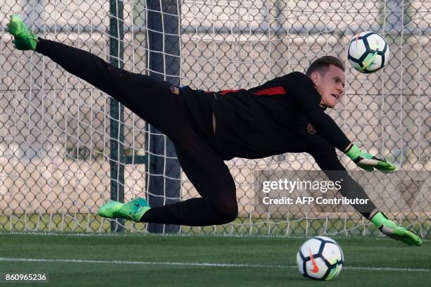 Barcelona's German goalkeeper Marc-Andre Ter Stegen dives for a ball during a training session at the Joan Gamper Sports Center in Sant Joan Despi,...