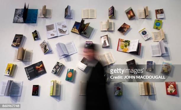 Visitor walks past a book display at the Frankfurt Book Fair on October 13, 2017 in Frankfurt am Main, western Germany. France is this year's guest...