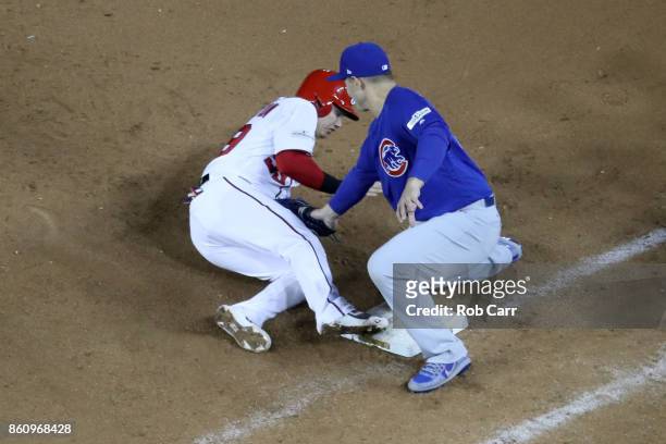 Anthony Rizzo of the Chicago Cubs applies the tag as Jose Lobaton of the Washington Nationals is picked off first base during the eighth inning in...
