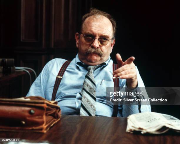 America actor Wilford Brimley points as he sits behind a desk in a scene from 'Absence of Malice' , 1981.
